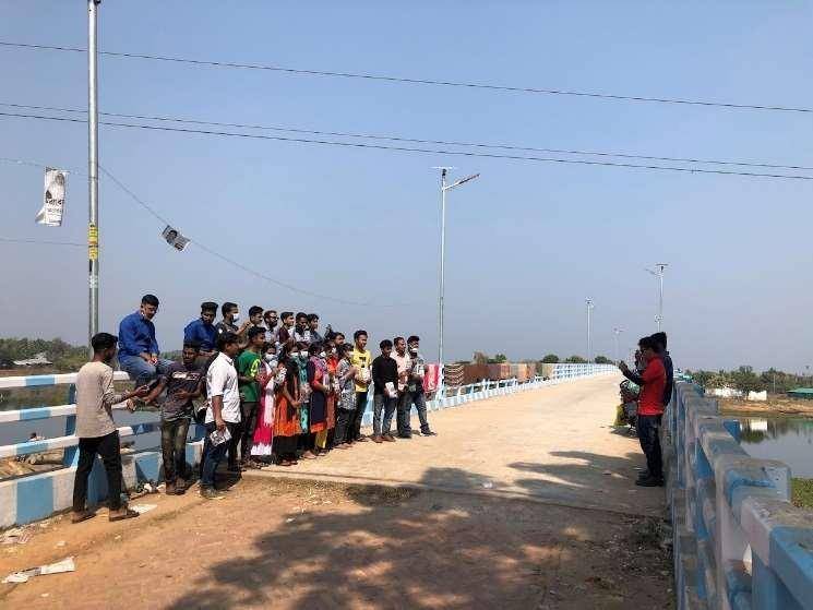 Solar street lights installed along a bridge in the Chittagong Hill Tracts, daytime, with the project team
